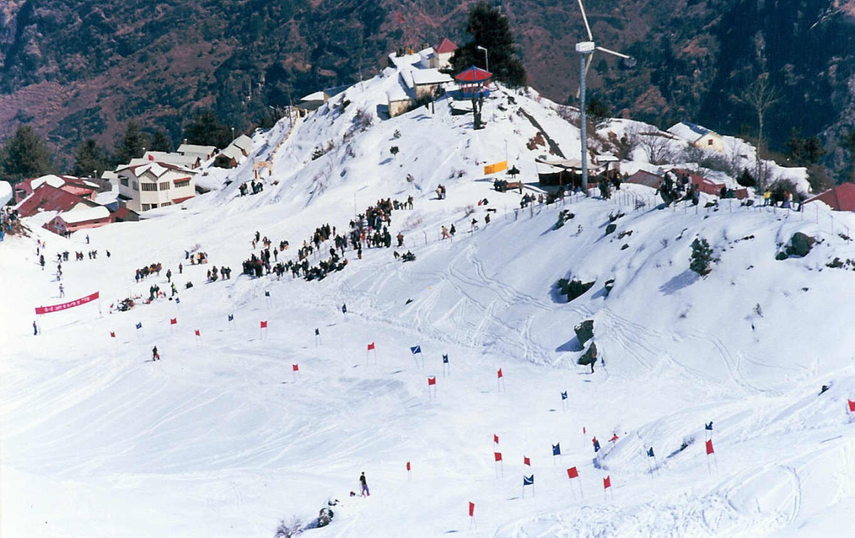 Auli in India - a group of people skiing down a snowy hill.