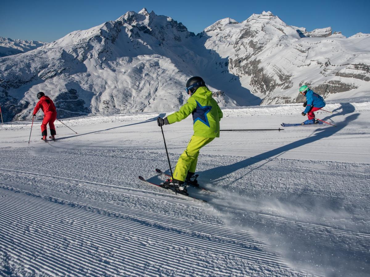 Brigels | ​Waltensburg | ​Andiast in Switzerland - a group of skiers skiing down a snowy slope.