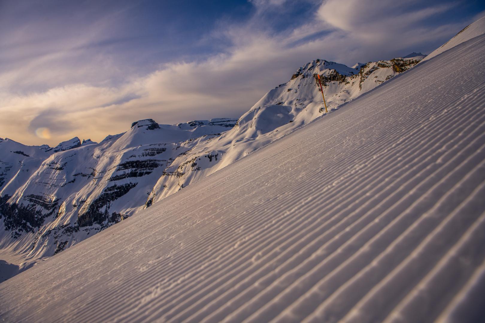 A skier descends snowy slopes in Brigels, Waltensburg, Andiast in Graubünden, Switzerland. A charming chalet and magnificent snow-capped mountains complete this picturesque winter sports scene.