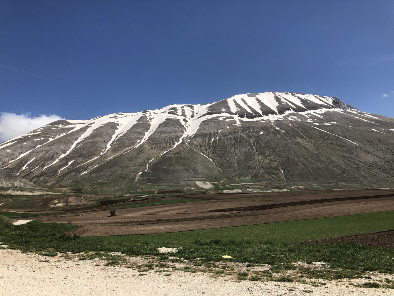 Pintura – Bolognola in Italy - a view of a mountain with snow on it.