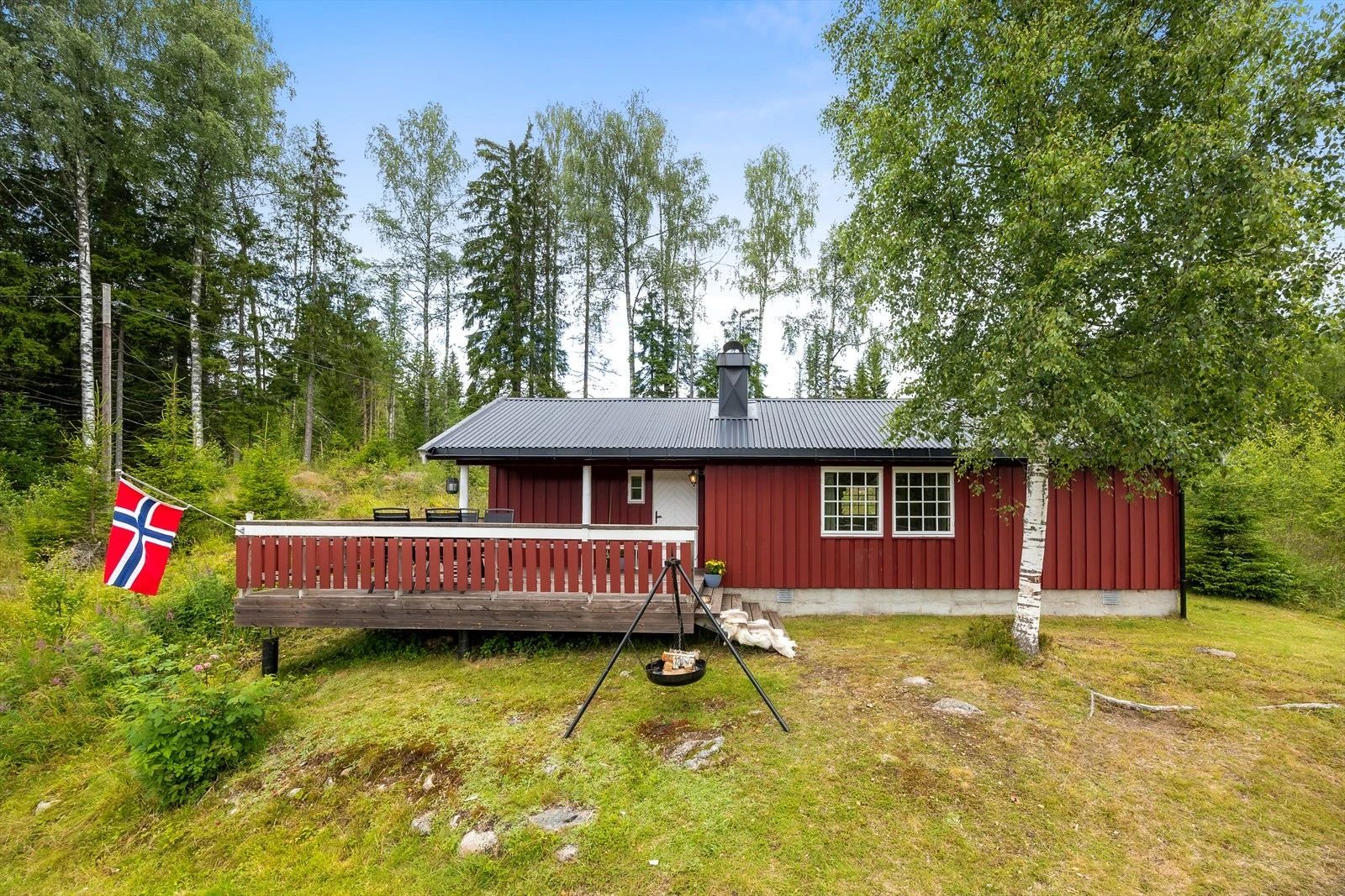 Hurdal in Norway - a red cabin with a flag on the porch.