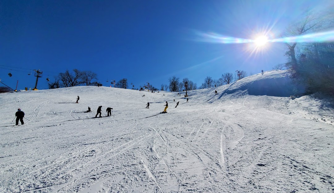Winter sports scene at Snow Creek in Missouri, USA illustrating a stunning winter landscape with a ski resort and a group of people enjoying their skiing adventure.