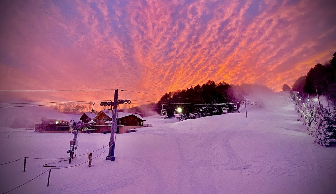 View of Woods Valley Ski Resort in Central New York, featuring an active winter sports scene with a running ski lift amidst stunning, snow-covered winter scenery.