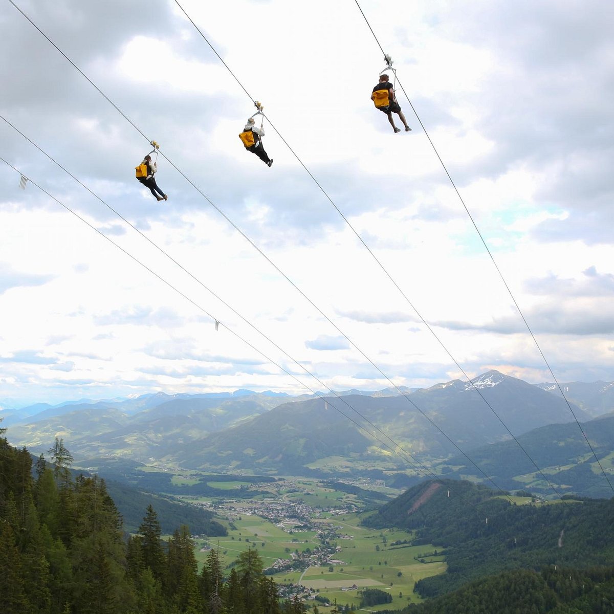 Stoderzinken – Gröbming in Austria - two people on a zip line in the mountains.