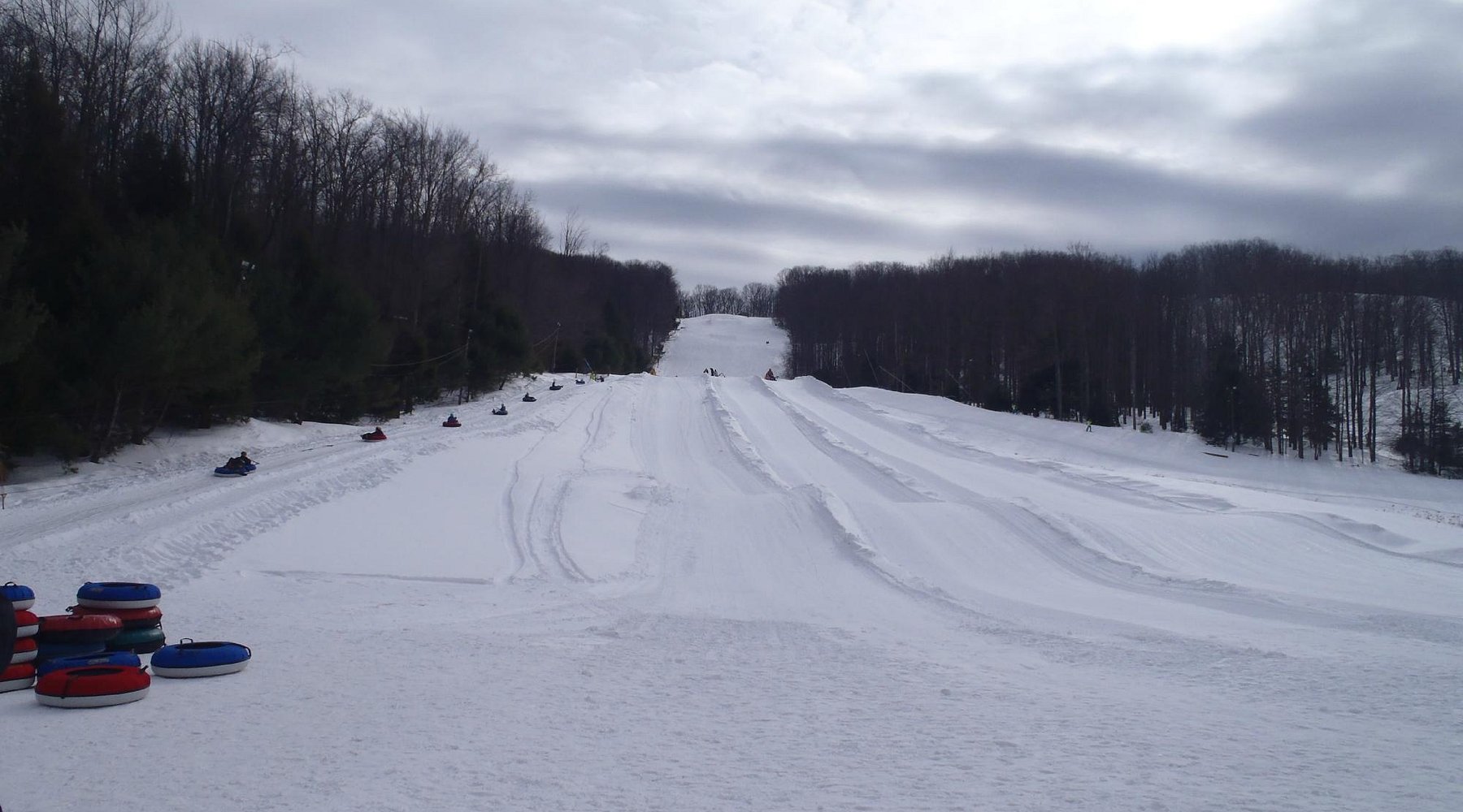 Skiing enthusiasts enjoying a day at Sawmill Mountain Resort in Pennsylvania, USA, with picturesque snow-covered slopes, ski lifts in operation and a bustling winter sports scene.