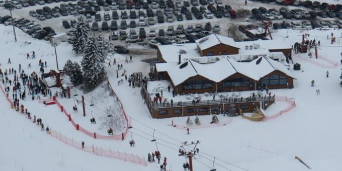 Ski resort at Little Switzerland, Wisconsin, featuring winter sports activities, a chalet, and a ski lift set against a vibrant snowy backdrop.