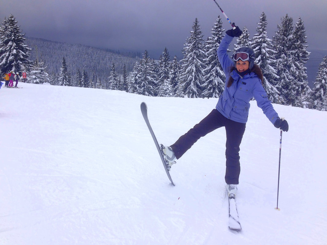 Mogosa in Romania - a woman in a blue jacket skiing down a hill.