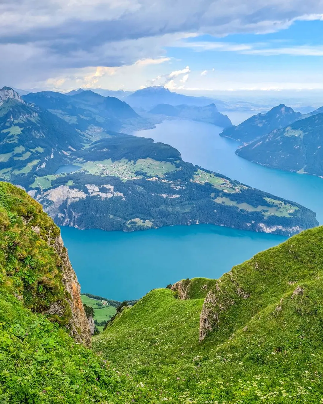 Stoos – Fronalpstock | ​Klingenstock in Switzerland - a view from the top of a mountain with a lake in the middle.