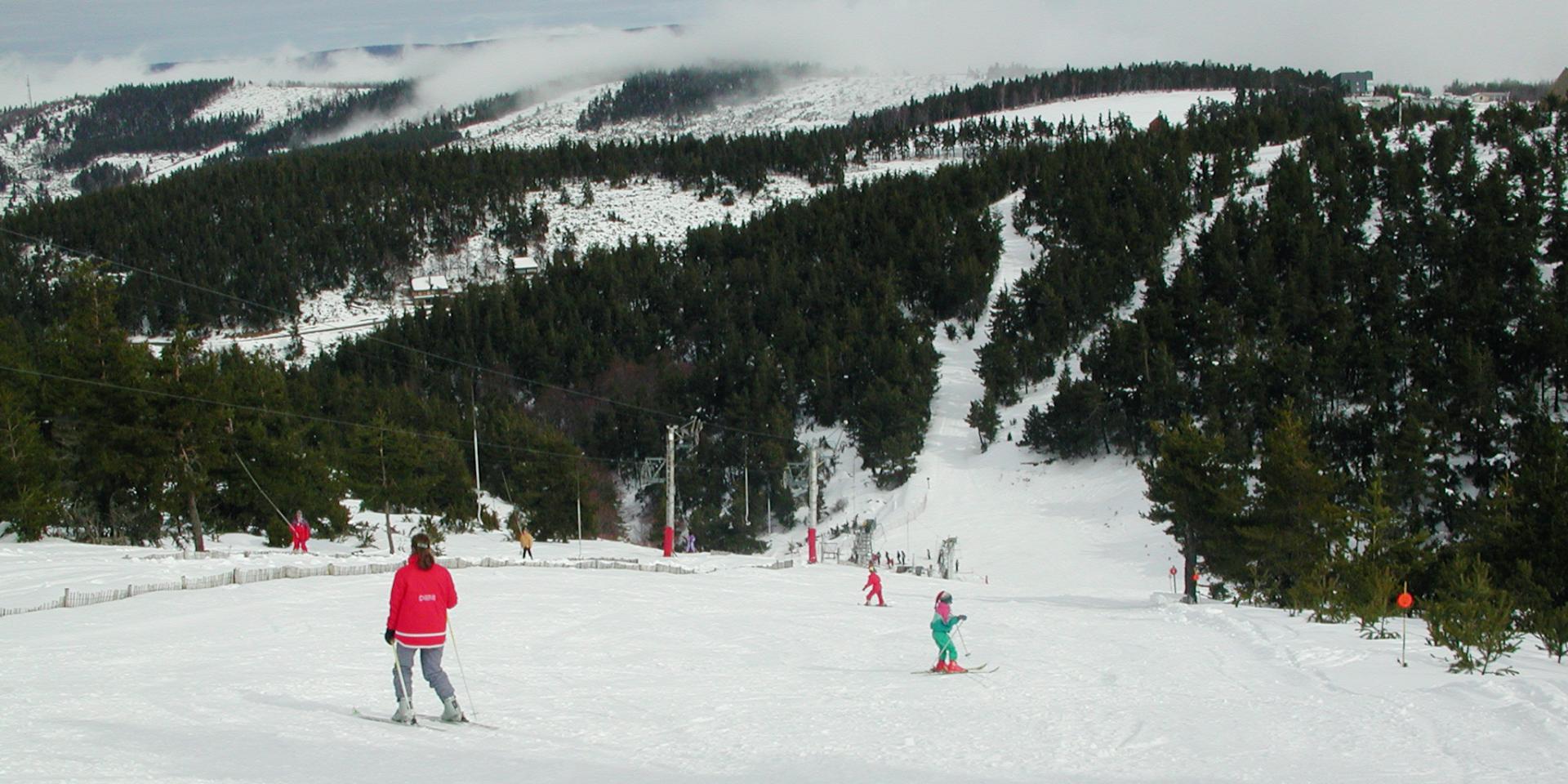 Bleymard Mont Lozère in France - a group of people skiing down a snowy slope.