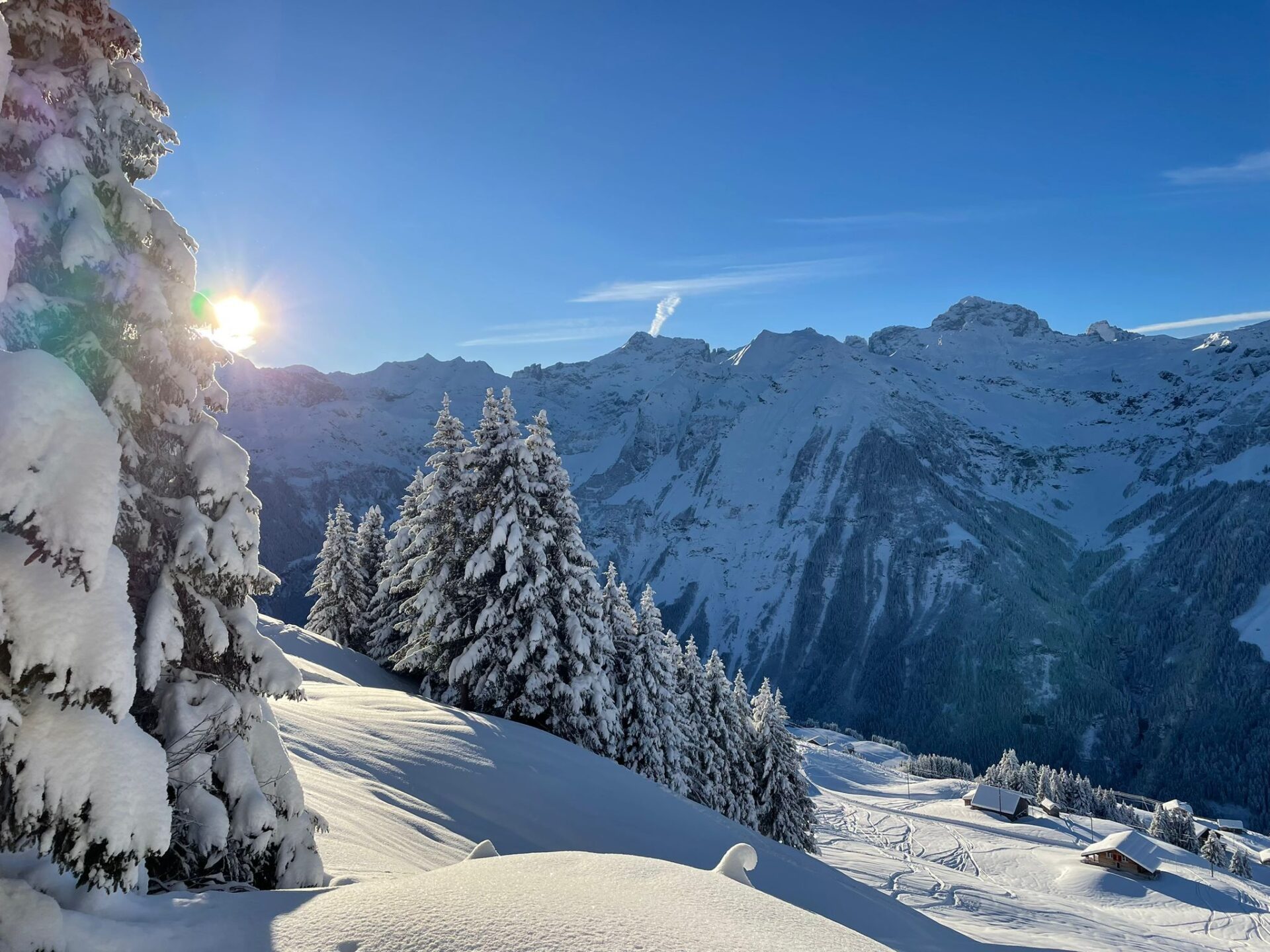 Ratzi – Spiringen in Switzerland - the sun shines on a snowy mountain in the austrian alps.