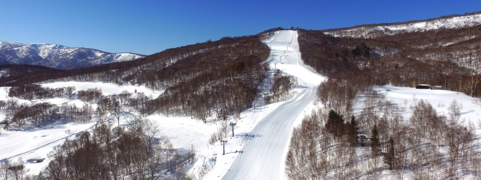 Asarigawa Onsen in Japan - an aerial view of a ski slope in the mountains.