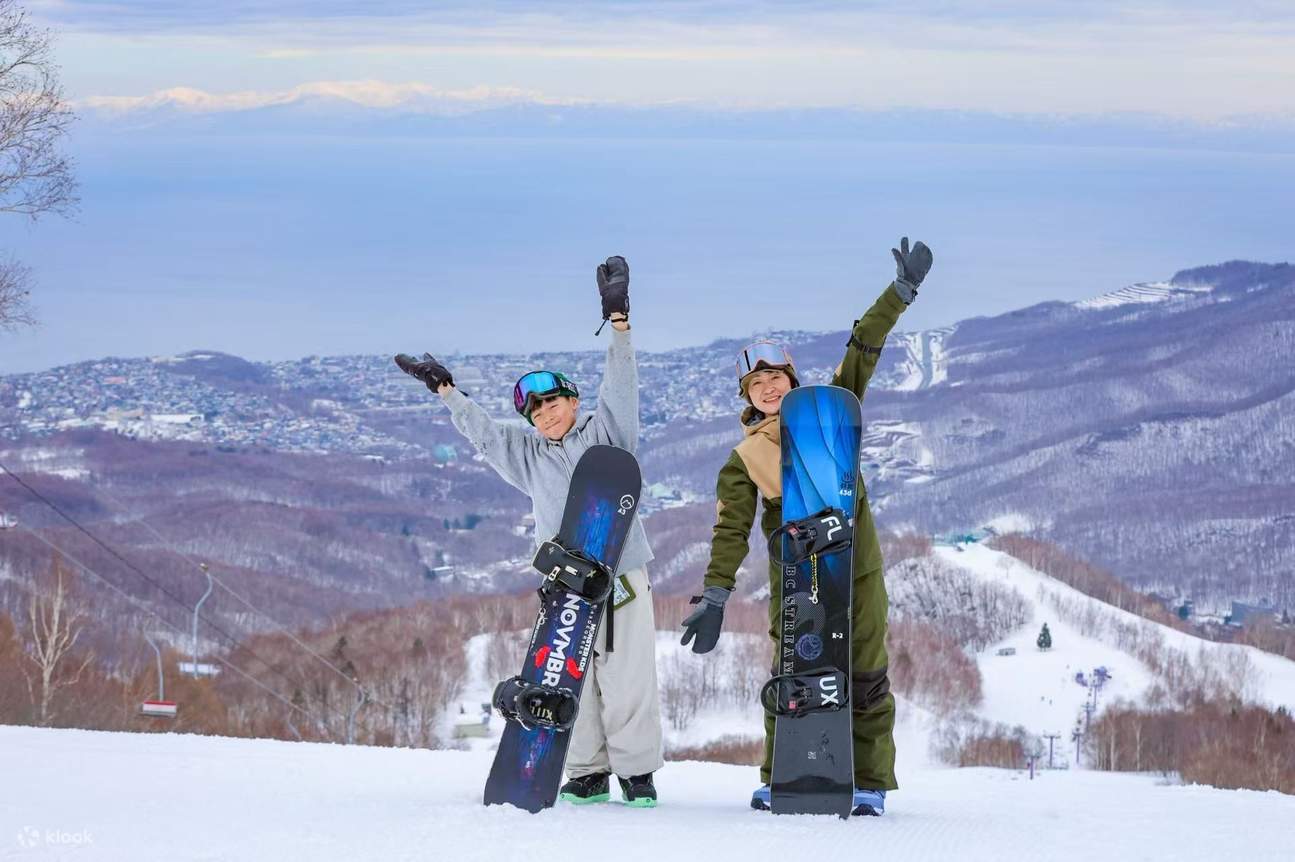 Asarigawa Onsen in Japan - two people standing on top of a snow covered hill.