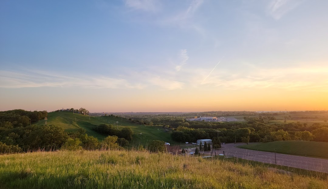 View of Great Bear Ski Valley chalet on a sunny day in South Dakota, with mountains and winter sports centre in the landscape.