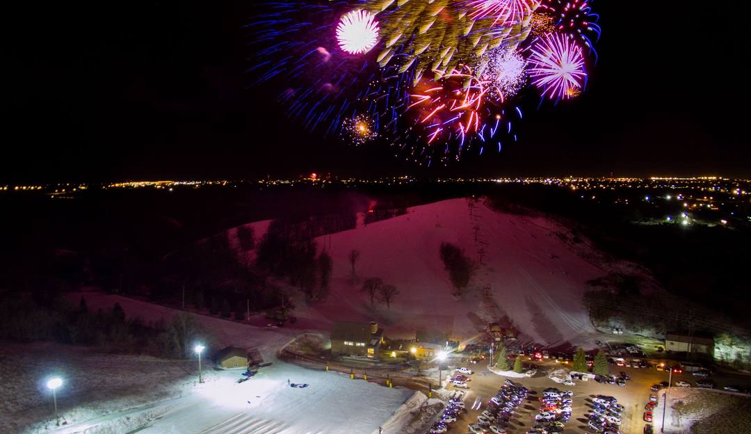 Winter scene at Great Bear Ski Valley in South Dakota, showcasing the ski resort with skiers enjoying winter sports amidst beautiful snowy scenery and a chalet in the view.