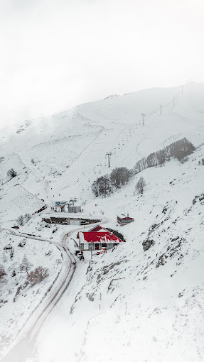 Bruncu Spina in Italy - a red house in the middle of a snowy mountain.