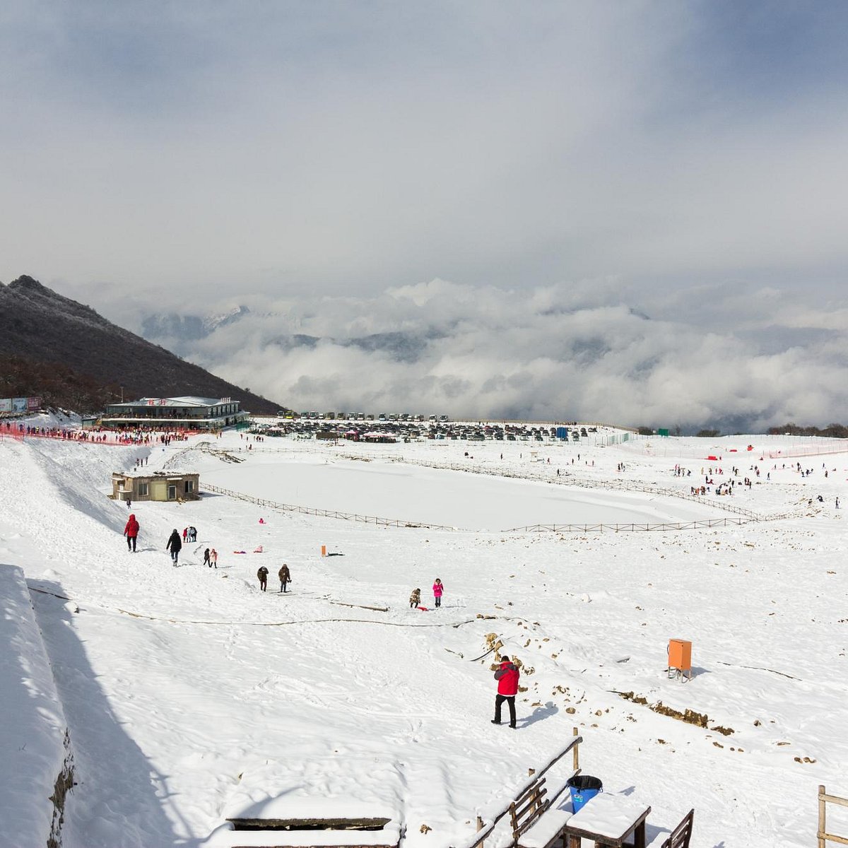 Jiudingshan Taiziling in China - a group of people skiing down a snow covered slope.