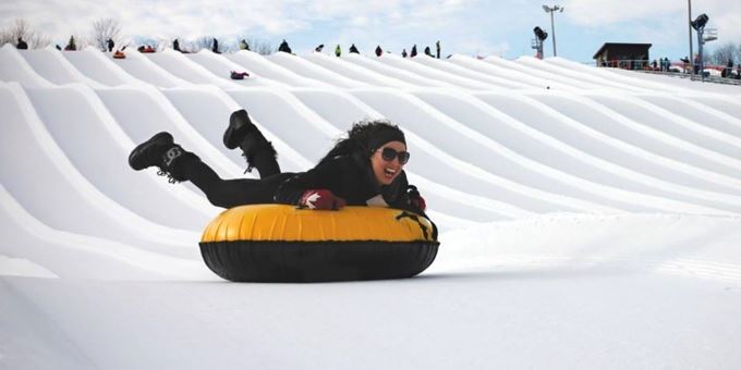 A snowboarder hitting the slopes at Sunburst Wisconsin giving an impressive display of winter sports amidst a serene snowy landscape.