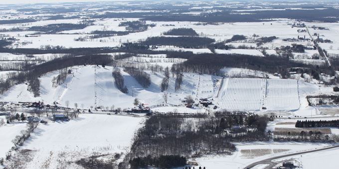 Winter sports scene at Sunburst in Wisconsin, USA featuring a bustling ski resort with snow-covered slopes, a quaint chalet, and stunning winter scenery.