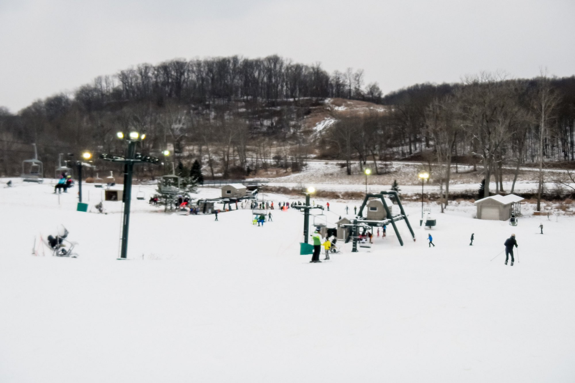 A winter sports scene at Boston Mills in Peninsula Ohio showcasing a ski resort with a ski lift. The slopes are covered in pristine white snow awaiting adventurous skiers.