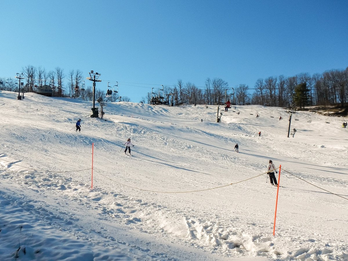 Boston Mills in USA - a group of people skiing down a snowy hill.