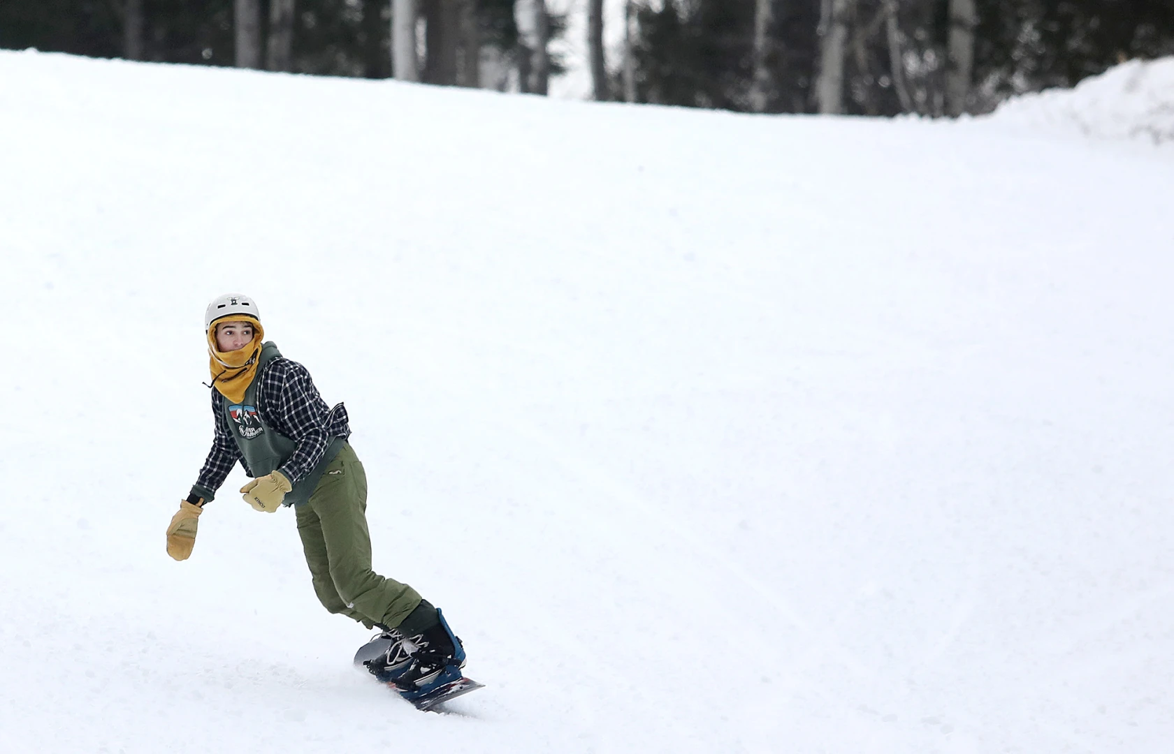 A snowboarder navigating the snow-covered slopes at Chester Bowl in Minnesota, USA. The pristine white snow and the thrill of the ride perfectly encapsulating the exhilaration of winter sports.