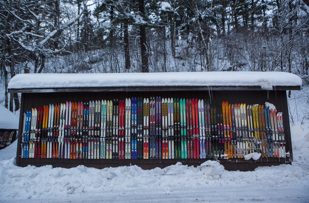 A lively winter sports scene at Chester Bowl in Minnesota USA. Skiers and snowmobiles can be seen enjoying the snow-dusted ski resort.