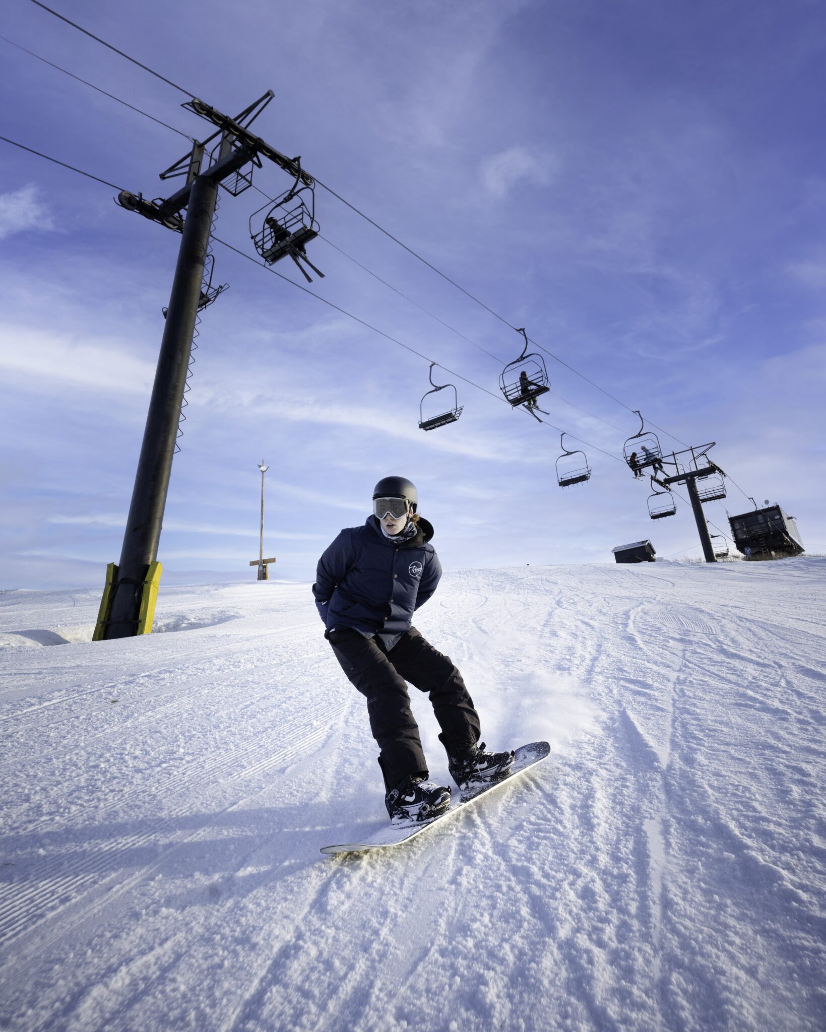 Sunridge in Canada - a man riding a snowboard down a snow covered slope.