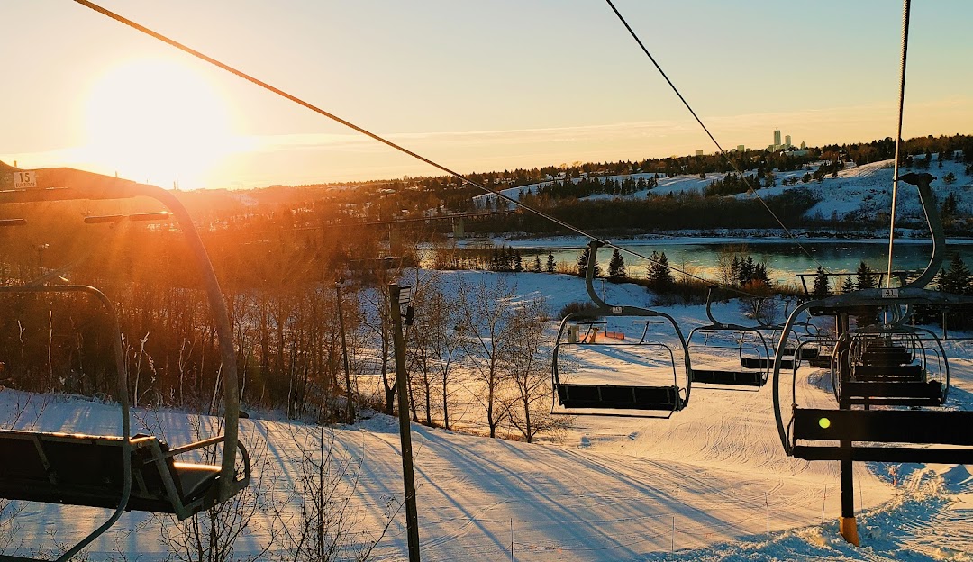 Ski lift with skier at Sunridge in Alberta, Canada during winter. The ski resort is alive with sports activity amidst a spectacular winter landscape.
