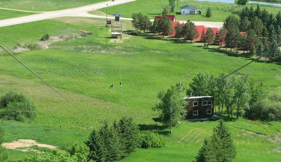 A bustling ski resort at Holiday Mountain in Manitoba, Canada featuring a prominent ski lift and a cozy chalet surrounded by snowy slopes, capturing the vibrant spirit of winter sports activities.