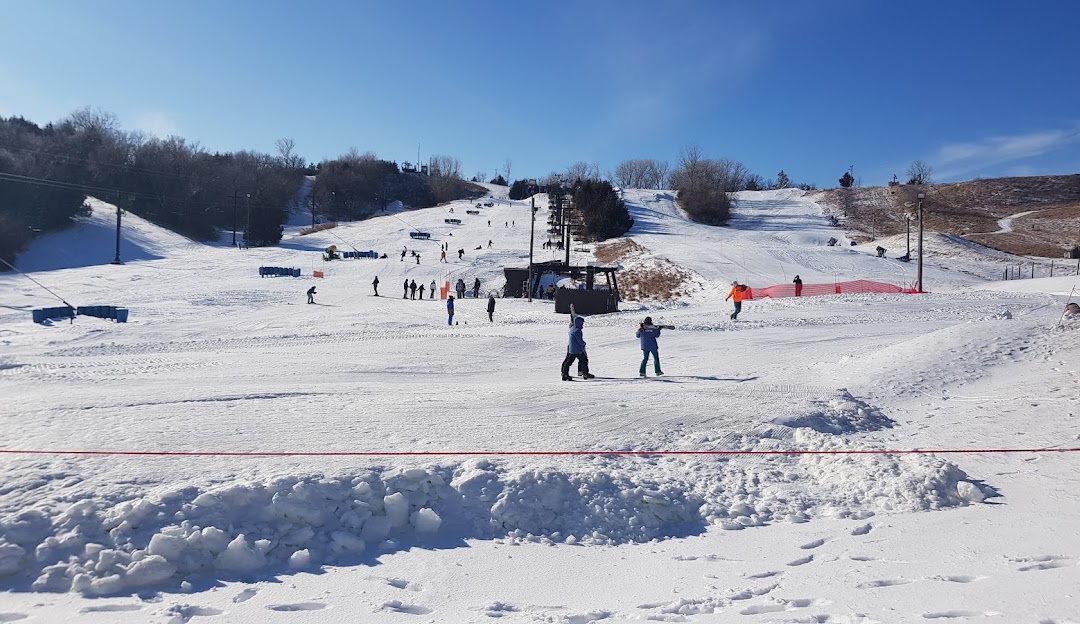 Winter scene at Mt Crescent in Iowa, USA showcasing the ski resort and sports centre. A skier in action adds excitement to this chilly landscape.