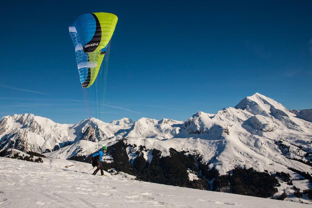 Vars | ​Risoul – La Forêt Blanche in France - a person flying a parachute over a snowy mountain.