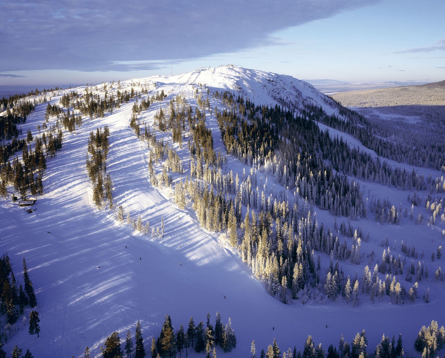 Idre Fjäll in Sweden - a mountain covered in snow and trees.