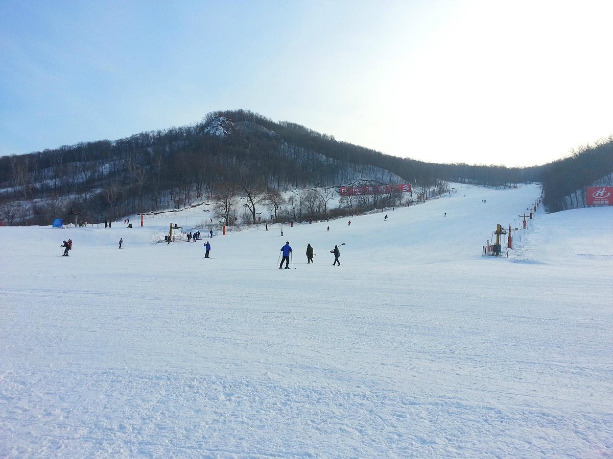 Jihua in China - a group of people skiing down a snowy slope.