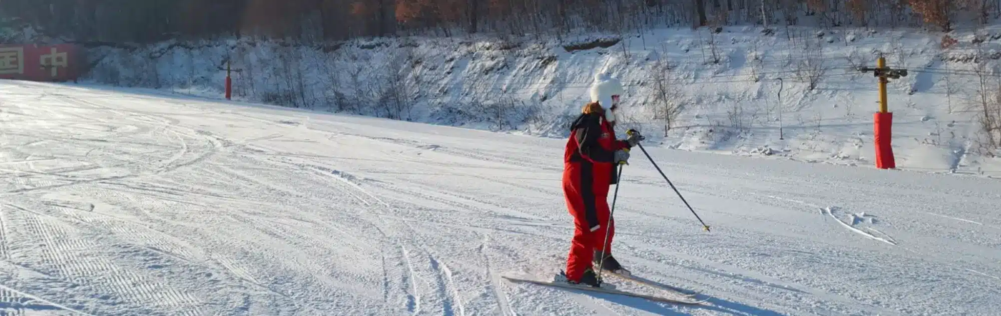 Jihua in China - a person in a red suit skiing down a hill.