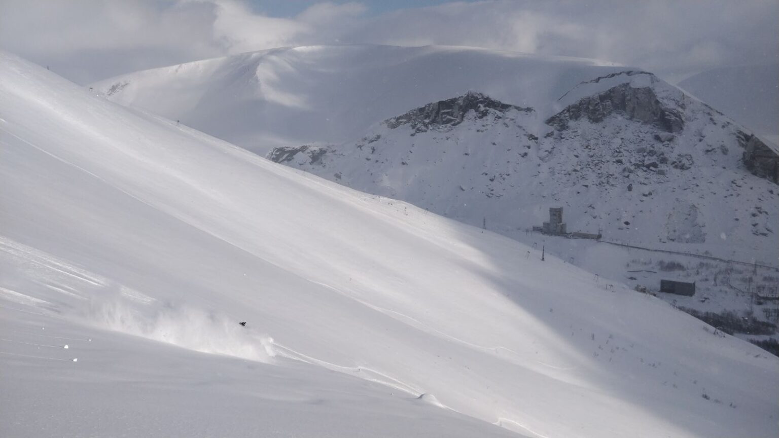 Kukisvumchorr in Russia - a person skiing down a snow covered mountain.