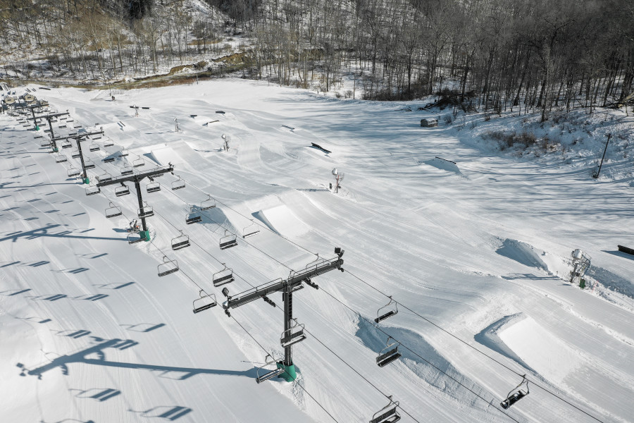 A vibrant winter sports scene at Brandywine ski resort in Northfield, Ohio, featuring a ski lift amidst stunning winter scenery.