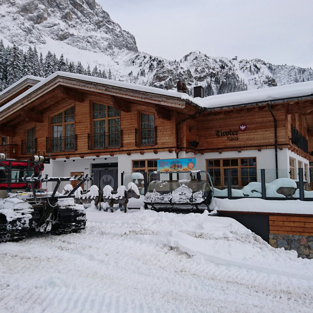 Ehrwalder Alm – Ehrwald in Austria - a snowmobile parked in front of a wooden house.