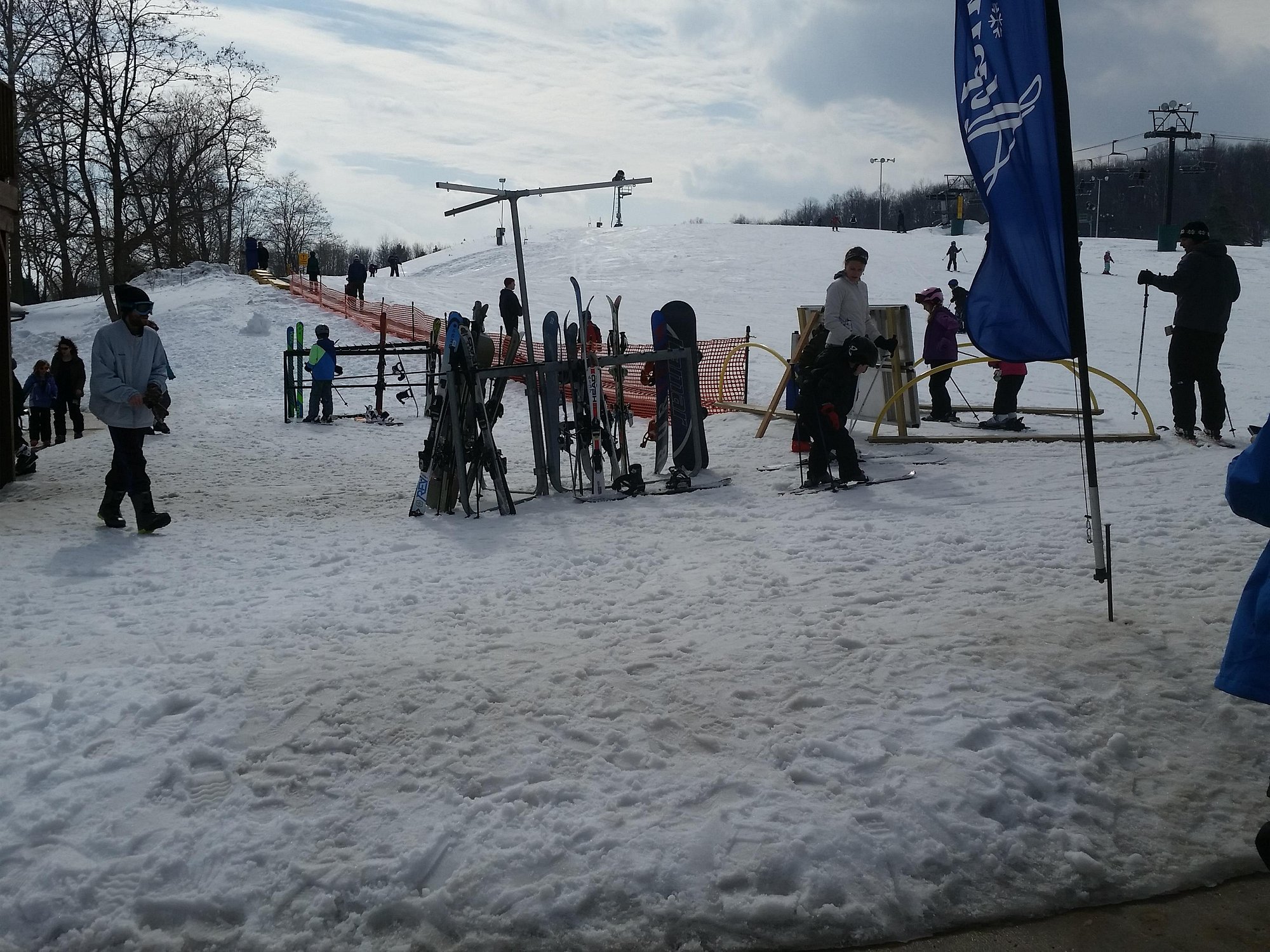 Ski resort Alpine Valley, Ohio, showcasing a lively winter sports scene surrounded by snowy slopes. Participants are seen skiing while ski lifts transport others. Popular for winter sporting activities.