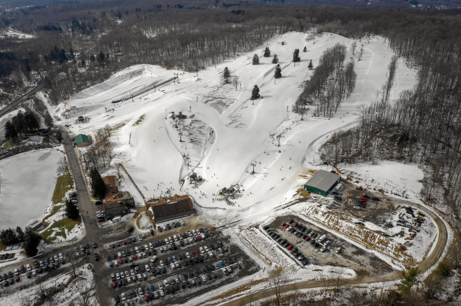 View of Alpine Valley ski resort in Ohio, featuring snow-covered slopes and a ski lift. Skiers and snowboarders are enjoying winter sports activities.