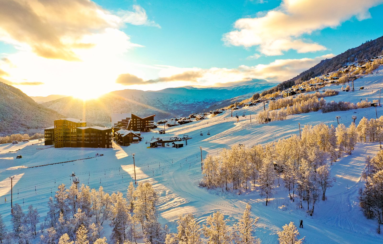 Myrkdalen in Norway - the sun is shining over a snowy mountain village.