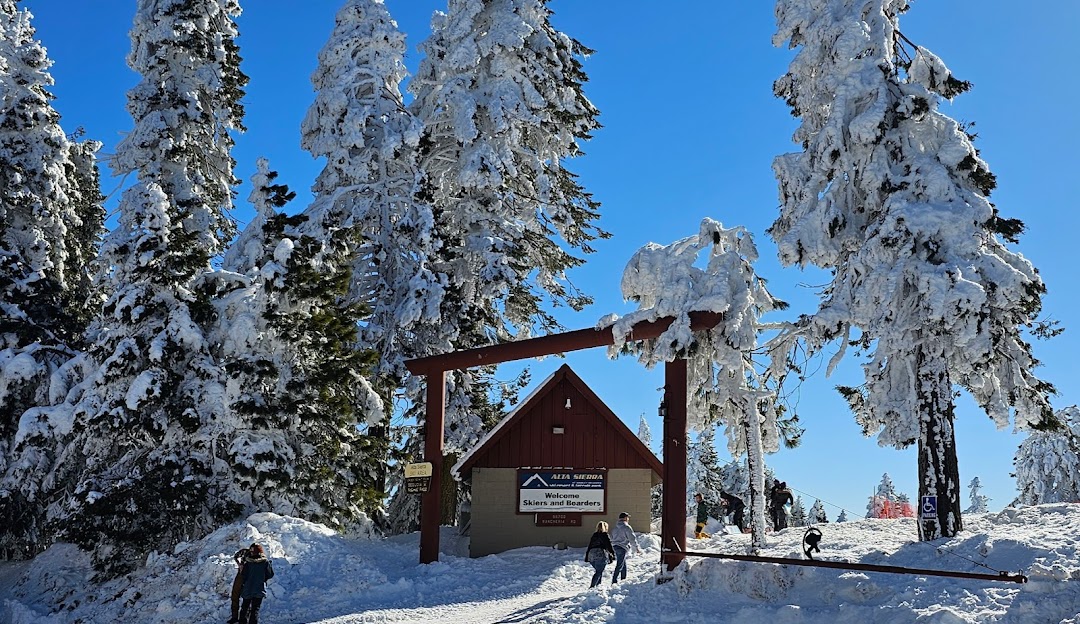 A ski resort in Alta Sierra - Shirley Meadows California featuring a vibrant winter sports scene. Snow blankets the landscape as skiers enjoy the ski lift and nearby winter sports center.