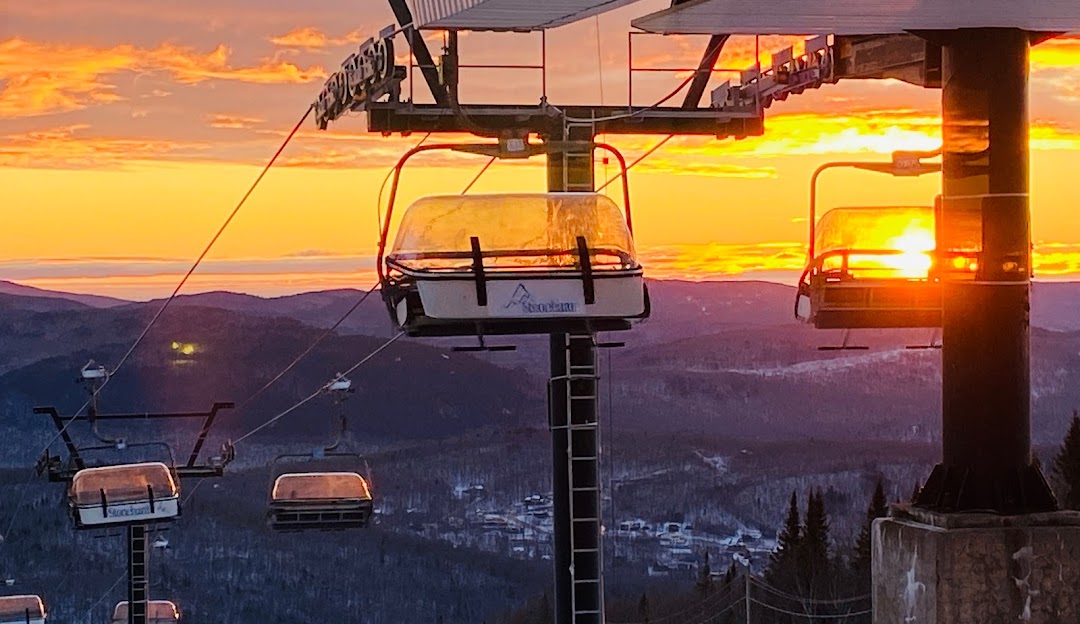 Stoneham in Canada - a ski lift going up the mountain at sunset.