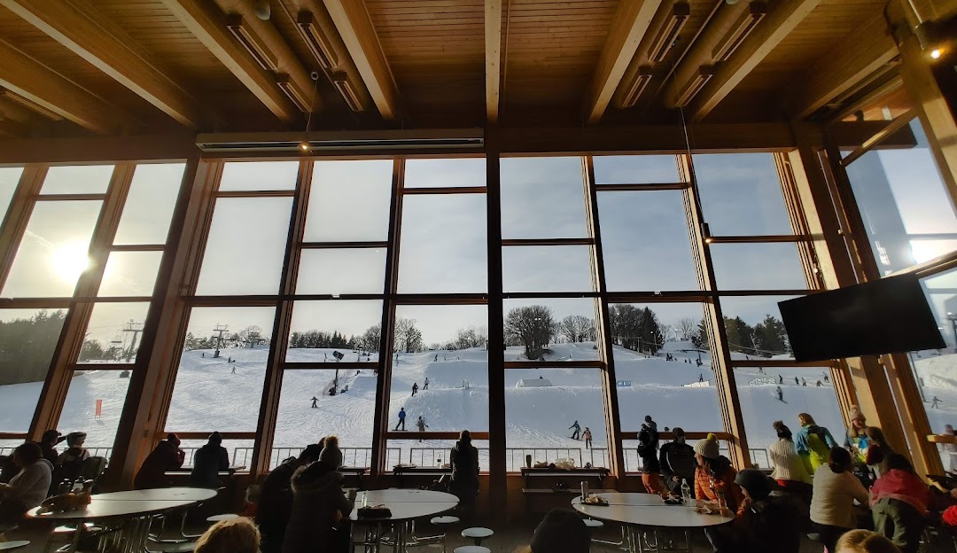 A lively winter sports scene at Hyland Hills, Minnesota featuring the sporting centre amidst beautiful winter scenery, offering a stunning view of the ski resort.