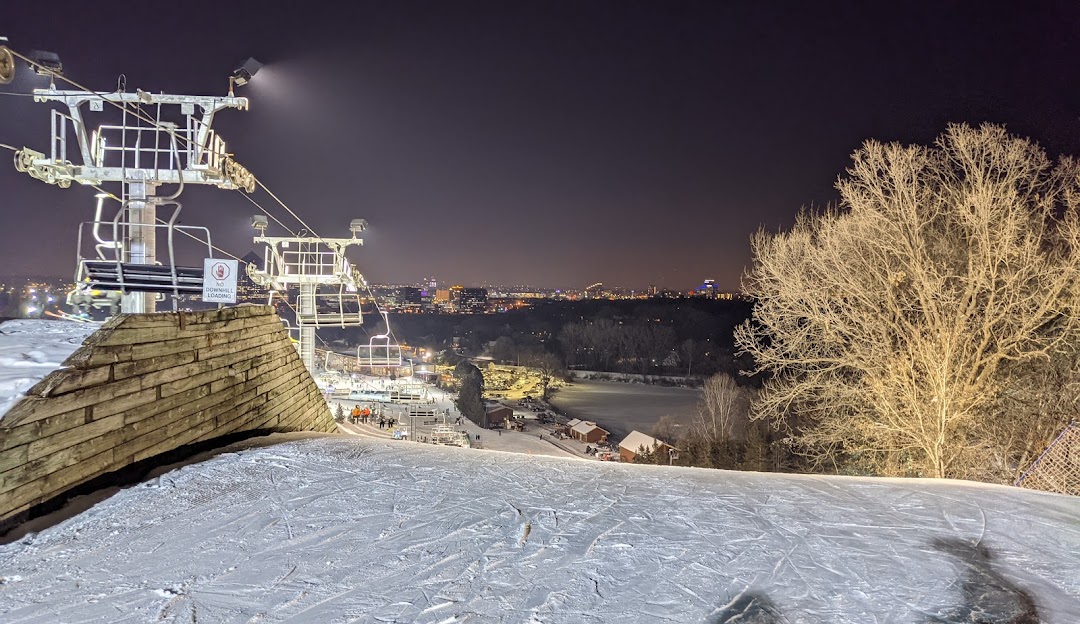 Winter sports scene at Hyland Hills, Minnesota featuring a ski lift, skiers in action, and stunning winter scenery as backdrop.