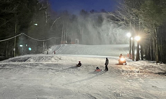 Campton Mountain in USA - a person skiing down a snowy hill at night.