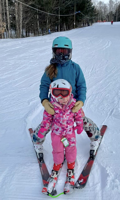 Campton Mountain in USA - a little girl riding a snowboard down a hill.