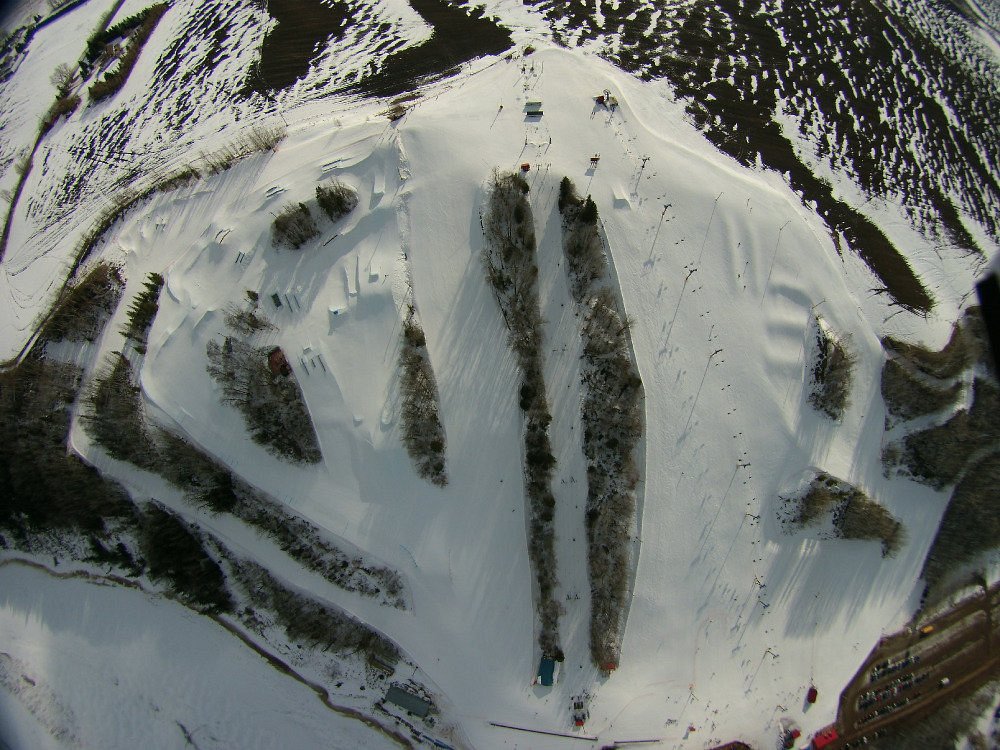 A skier is captured in action at the Rabbit Hill Snow Resort in Edmonton, Alberta. The bustling ski resort features a ski lift and terrain perfect for winter sports enthusiasts.
