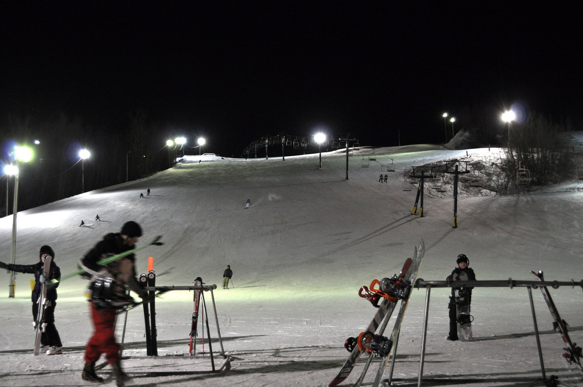 A skier preparing to descend at Rabbit Hill Snow Resort in Edmonton, Alberta, Canada. The chalet and winter sports facilities of the resort are faintly visible in the background.