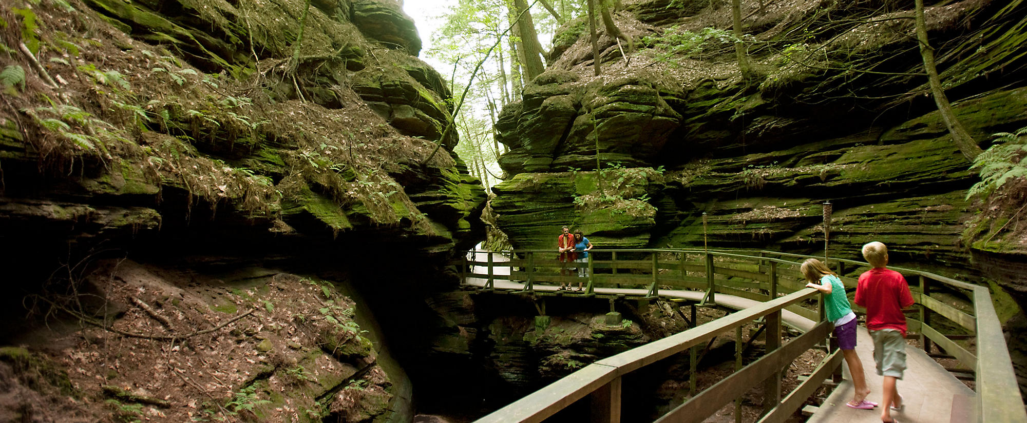 Christmas Mountain in USA - a couple of people walking on a bridge in the woods.