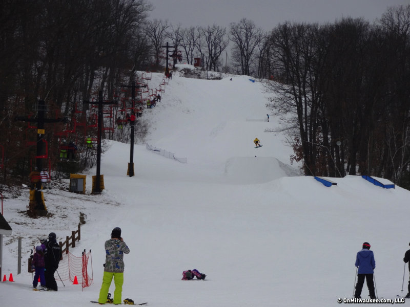 A skier taking on the slopes at Christmas Mountain Wisconsin a vibrant winter sports scene complete with a ski lift and snow-covered slopes at a ski resort.